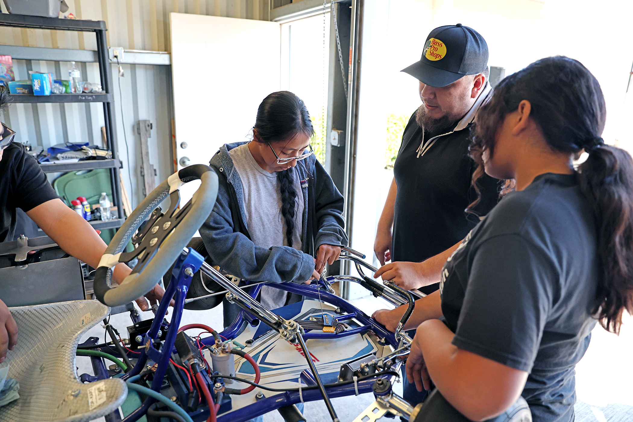 Students teacher work on go-kart