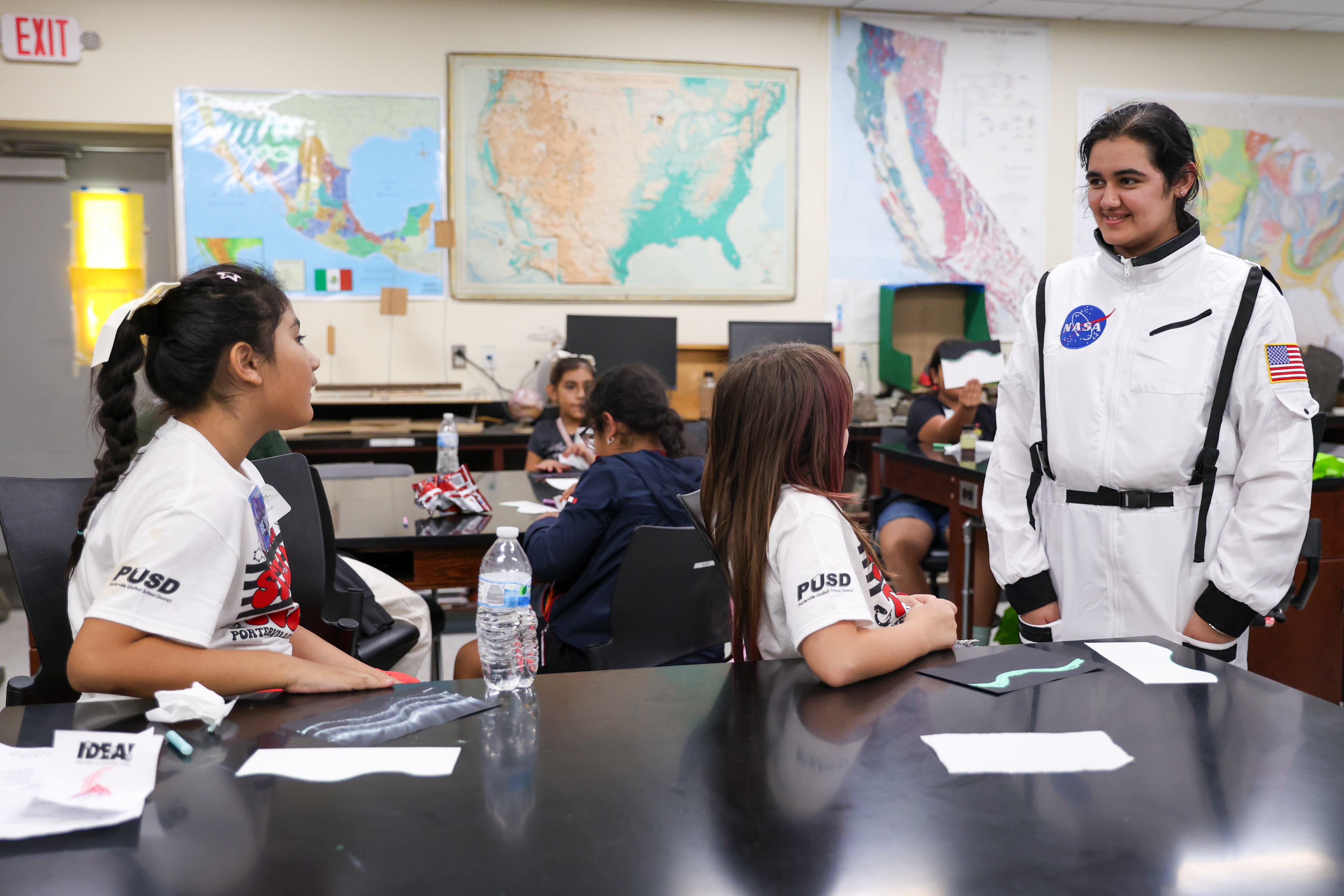 Girls talk to woman in NASA spacesuit