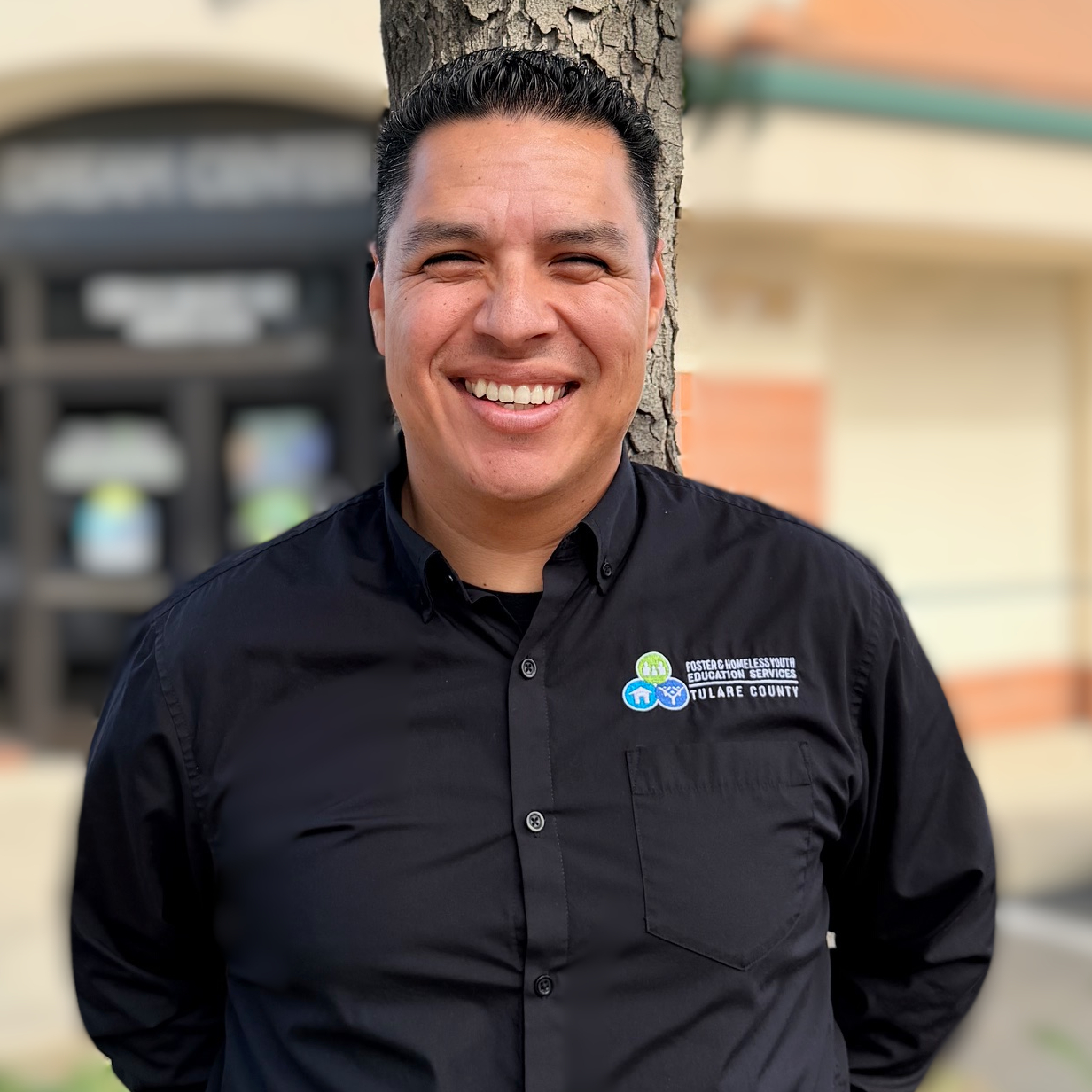 MISA Dream Center Male staff member wearing a black button up with dream center logo pocket size on the left side of his chest.