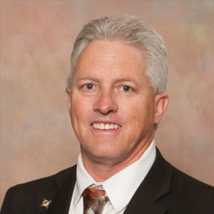 Man in suit with gray hair smiling