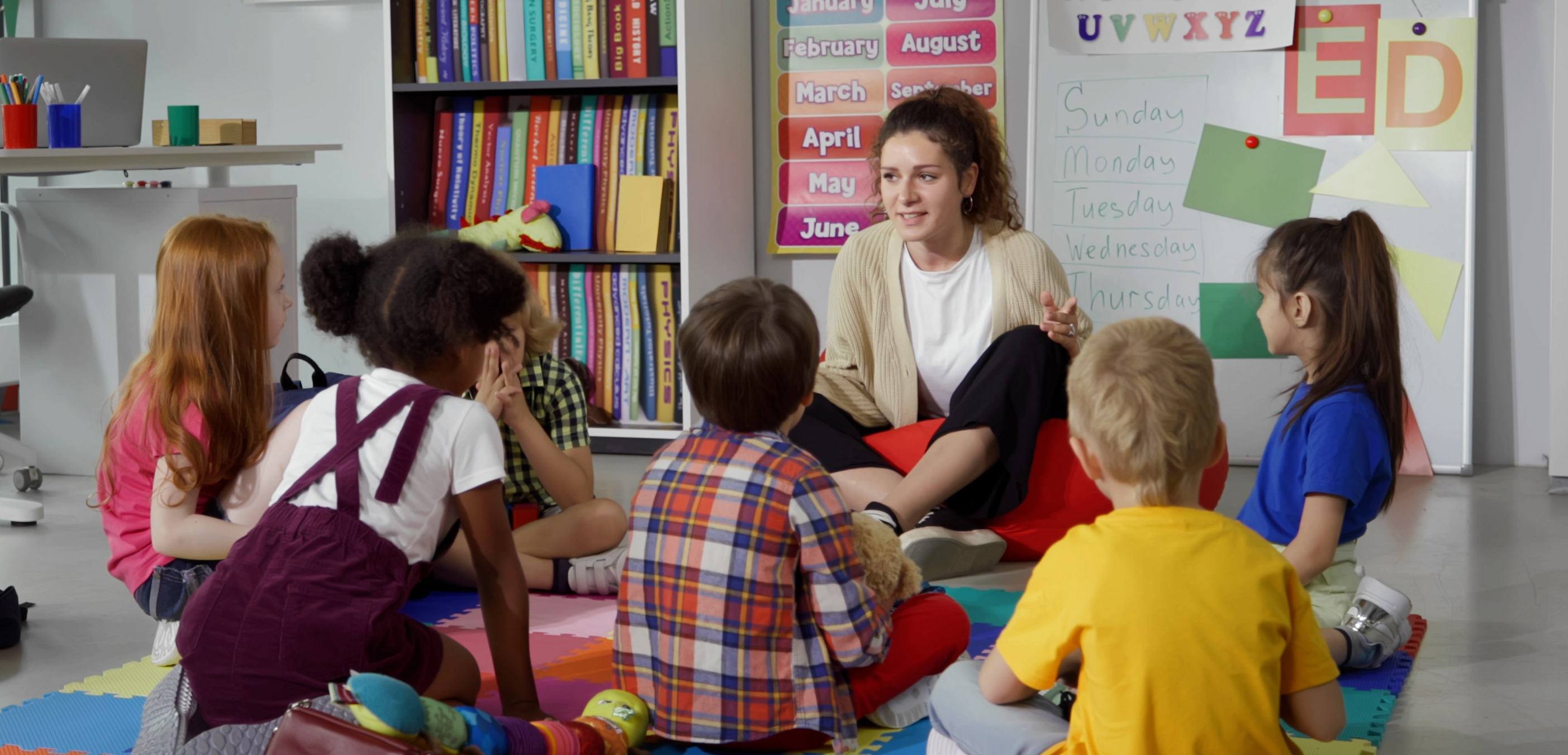 AdobeStock_614358465 Children sitting on floor with teacher